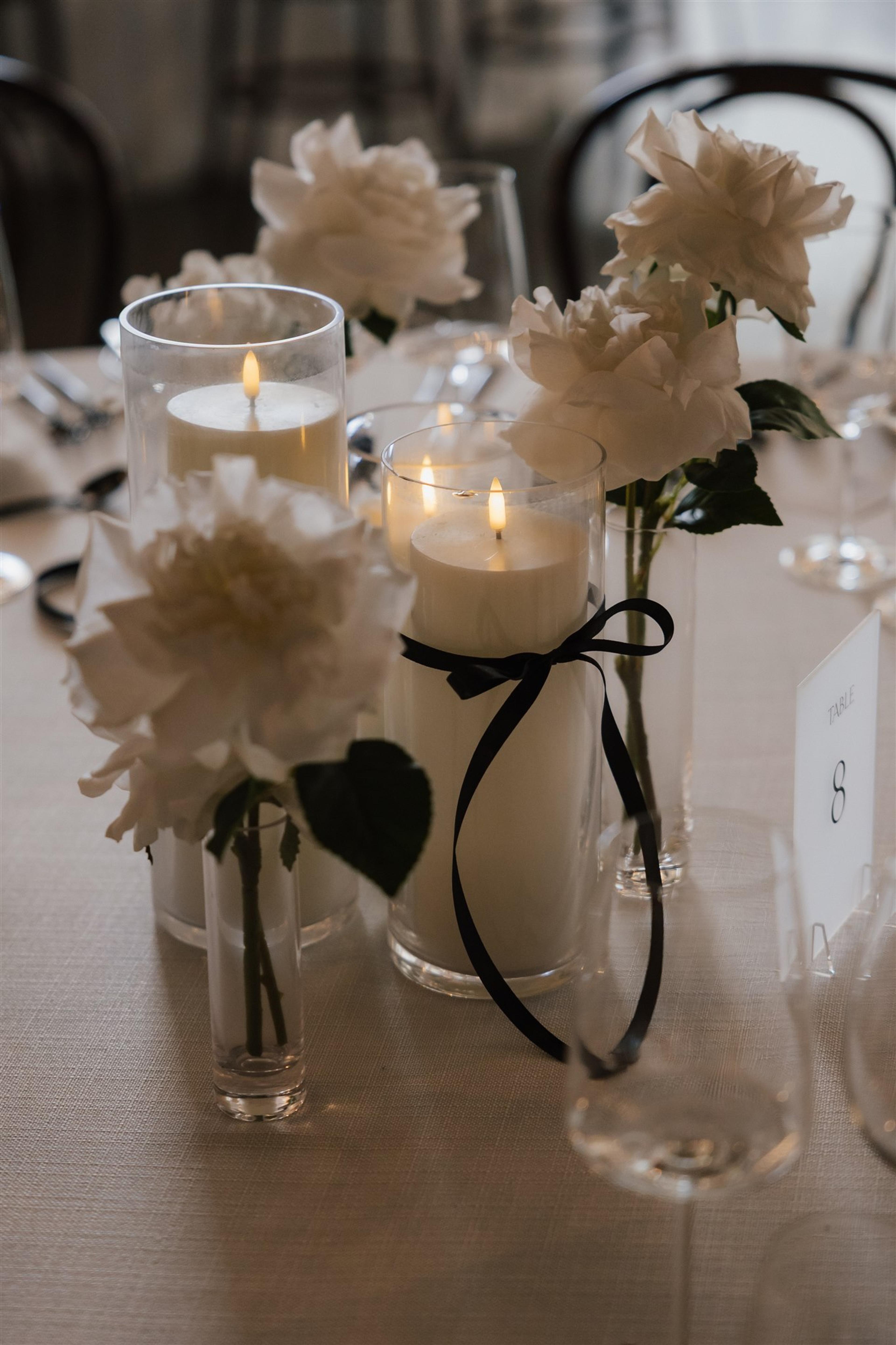 White rose table styling with candlelight and black ribbon details for Rochelle and Jeff’s wedding reception at The Valley Estate Gold Coast.