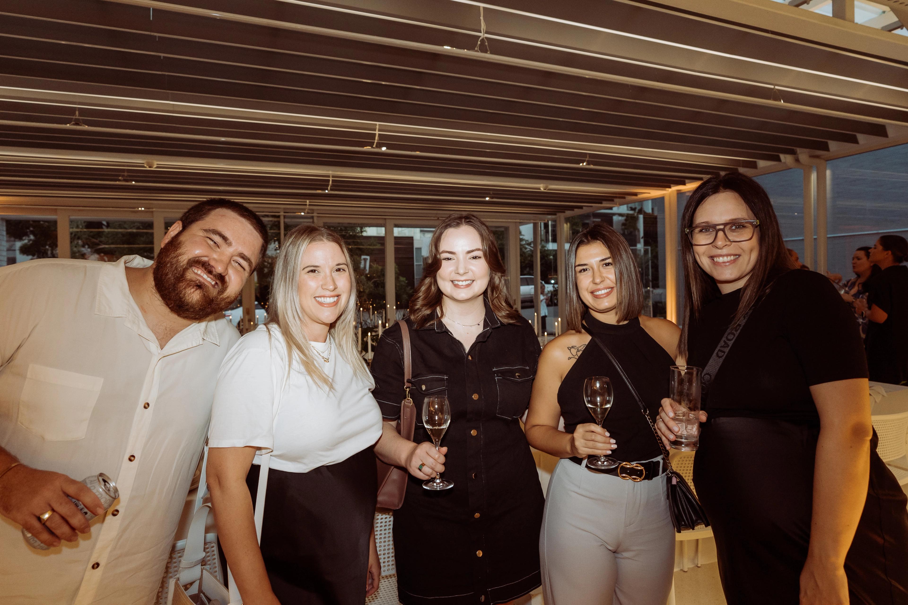 Guests at the Industry Beans Newstead brand activation, photographed inside the styled Brisbane event space with candlelit tables behind them.