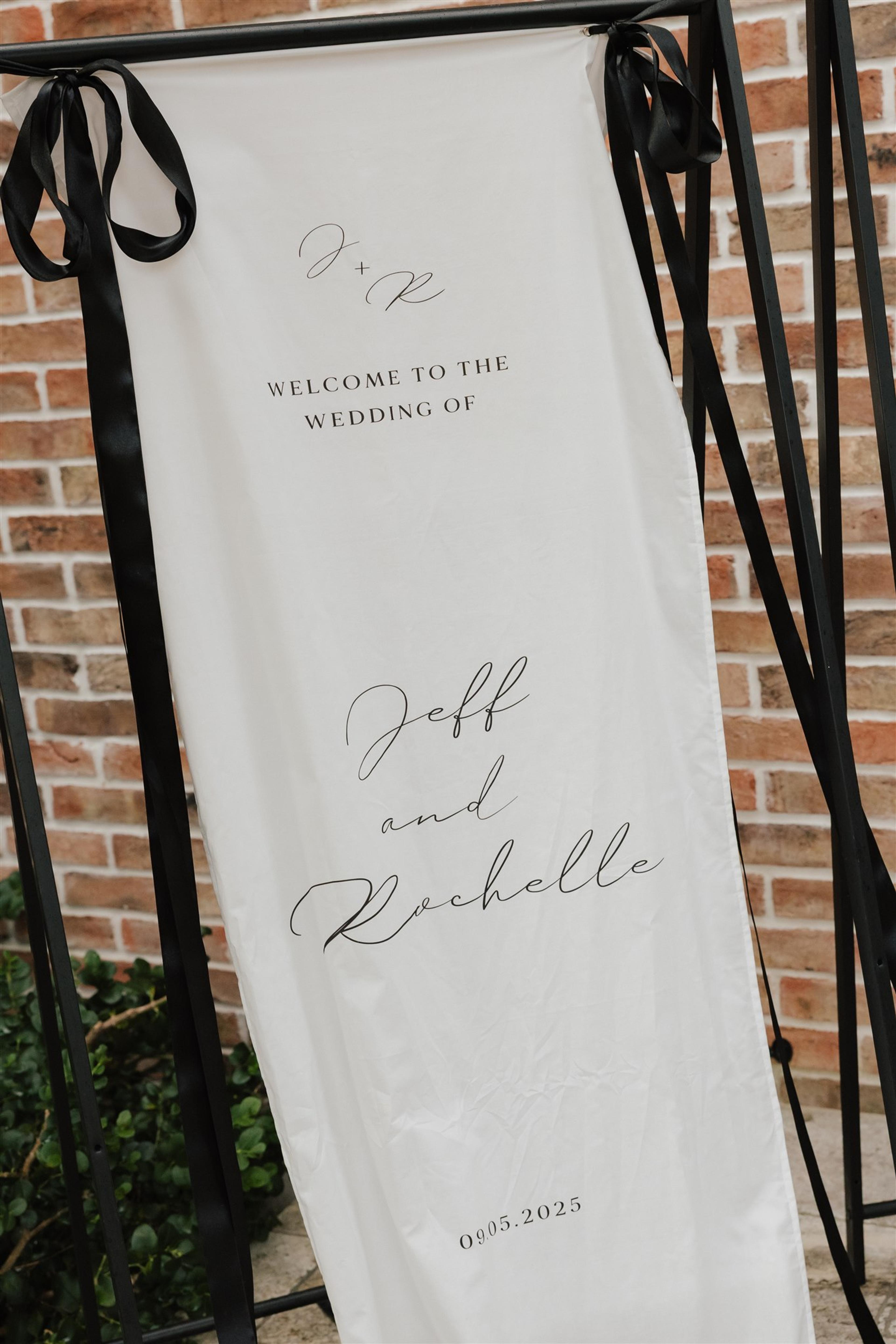 Fabric wedding welcome sign with black ribbon details for Rochelle and Jeff’s wedding at The Valley Estate Gold Coast.