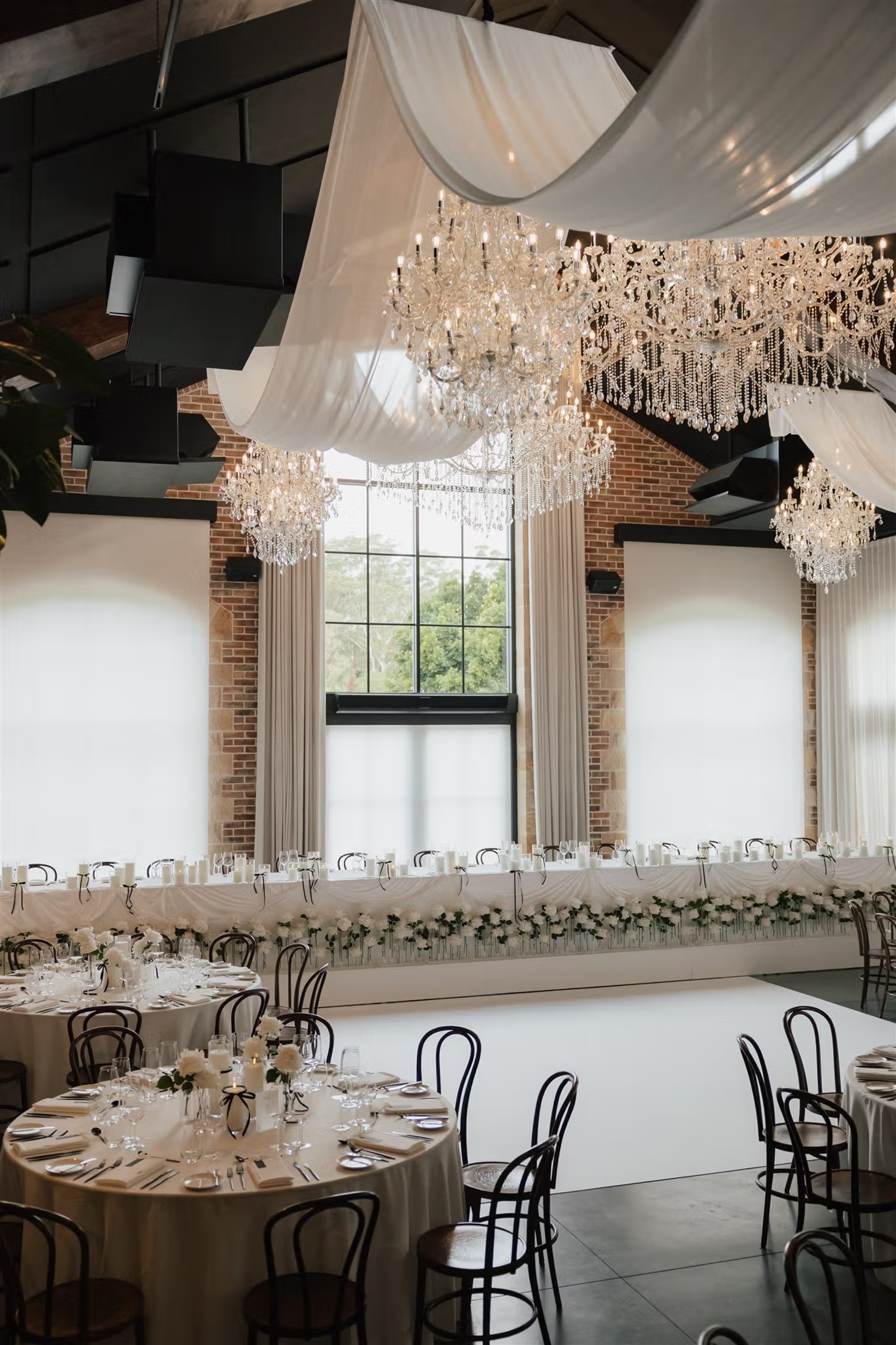 White draping and crystal chandeliers above the wedding reception space at The Valley Estate Gold Coast.