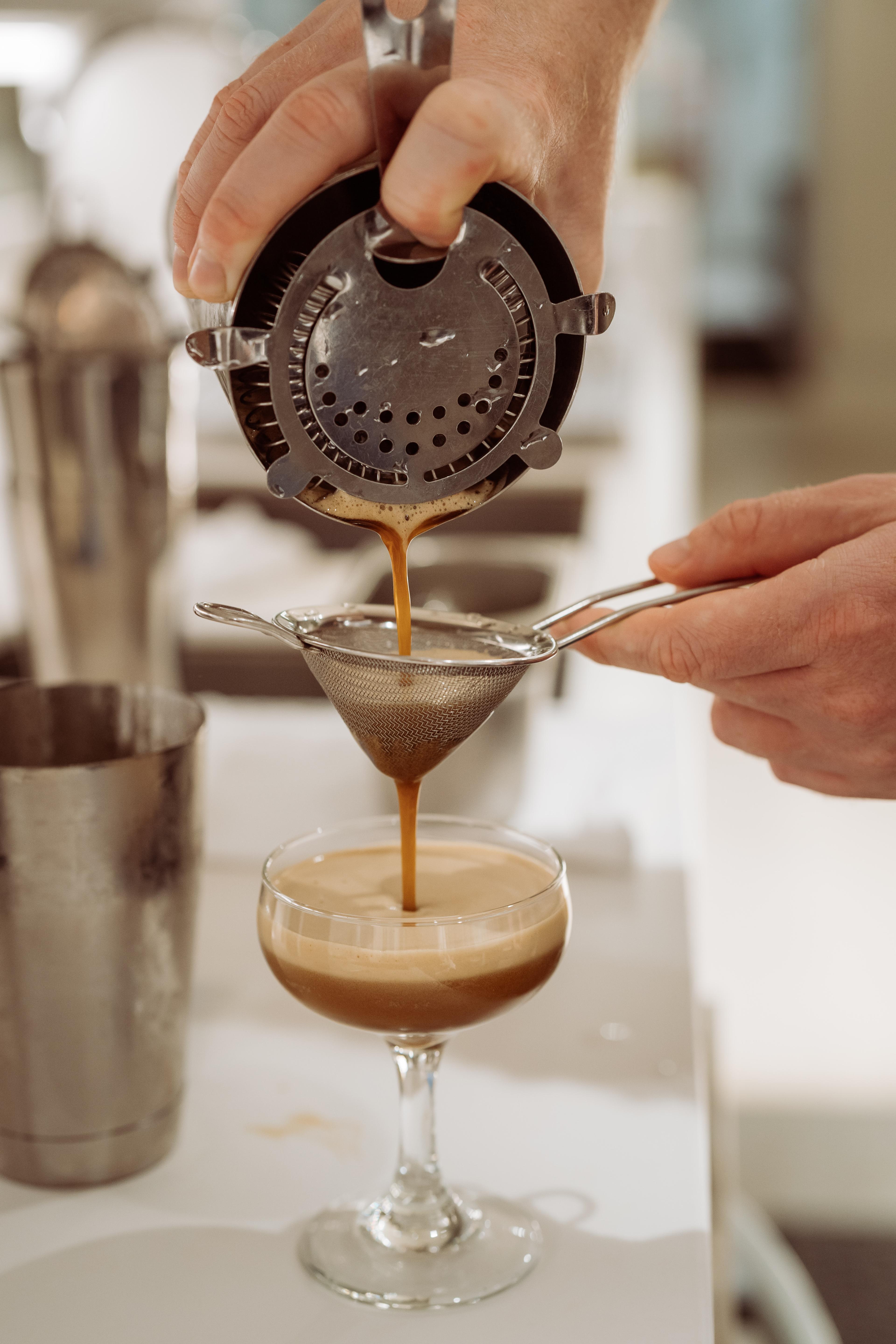 Espresso martini being poured through a cocktail strainer at the Industry Beans Newstead brand activation.