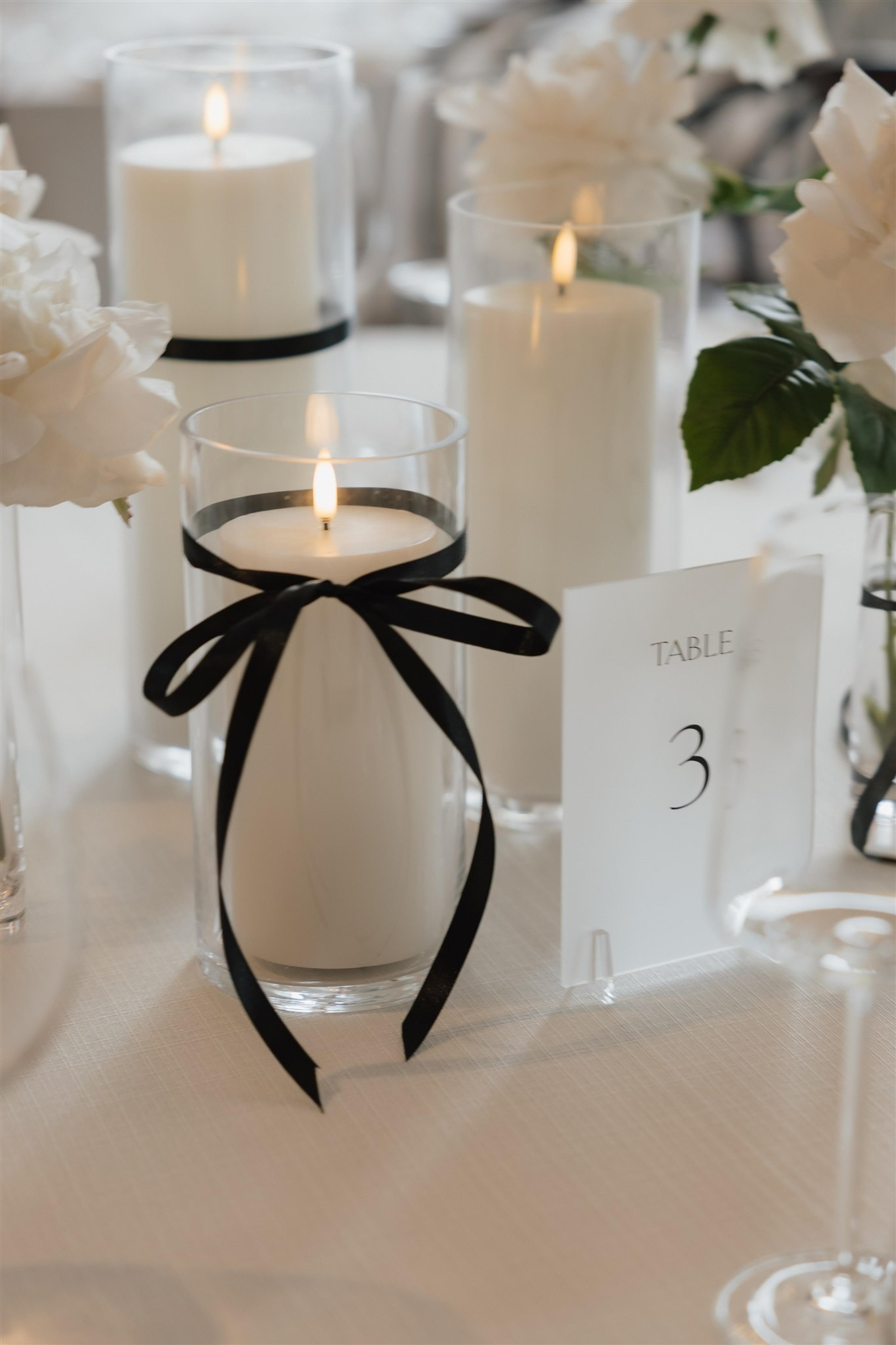Close-up of black ribbon candle styling and table number three at Rochelle and Jeff’s wedding reception on the Gold Coast.