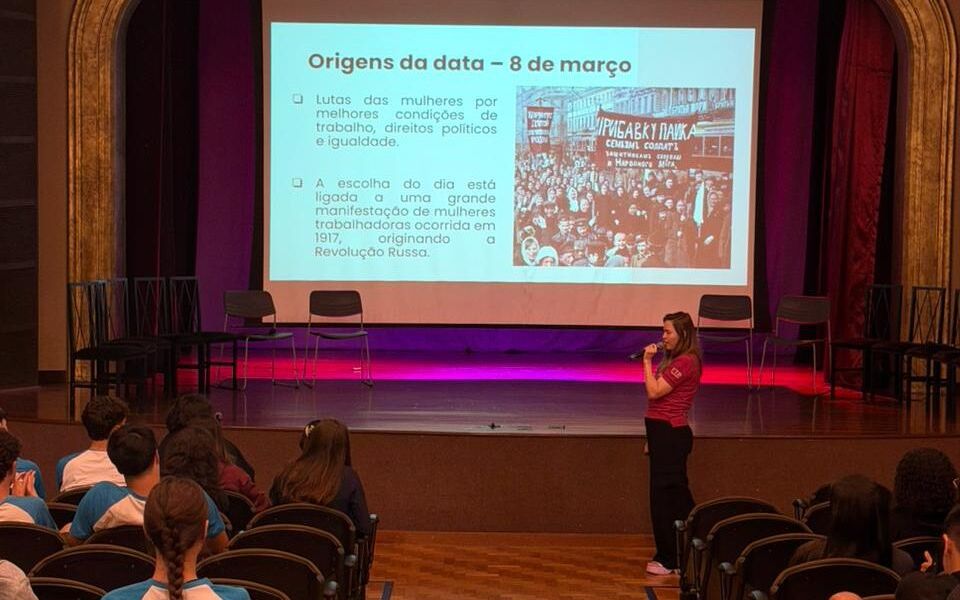 Professora apresenta a origem do Dia Internacional da Mulher a estudantes no teatro