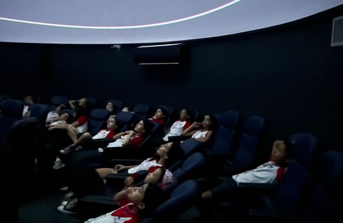 Alunos do 5º ano assistem a uma projeção no Planetário PUC Minas