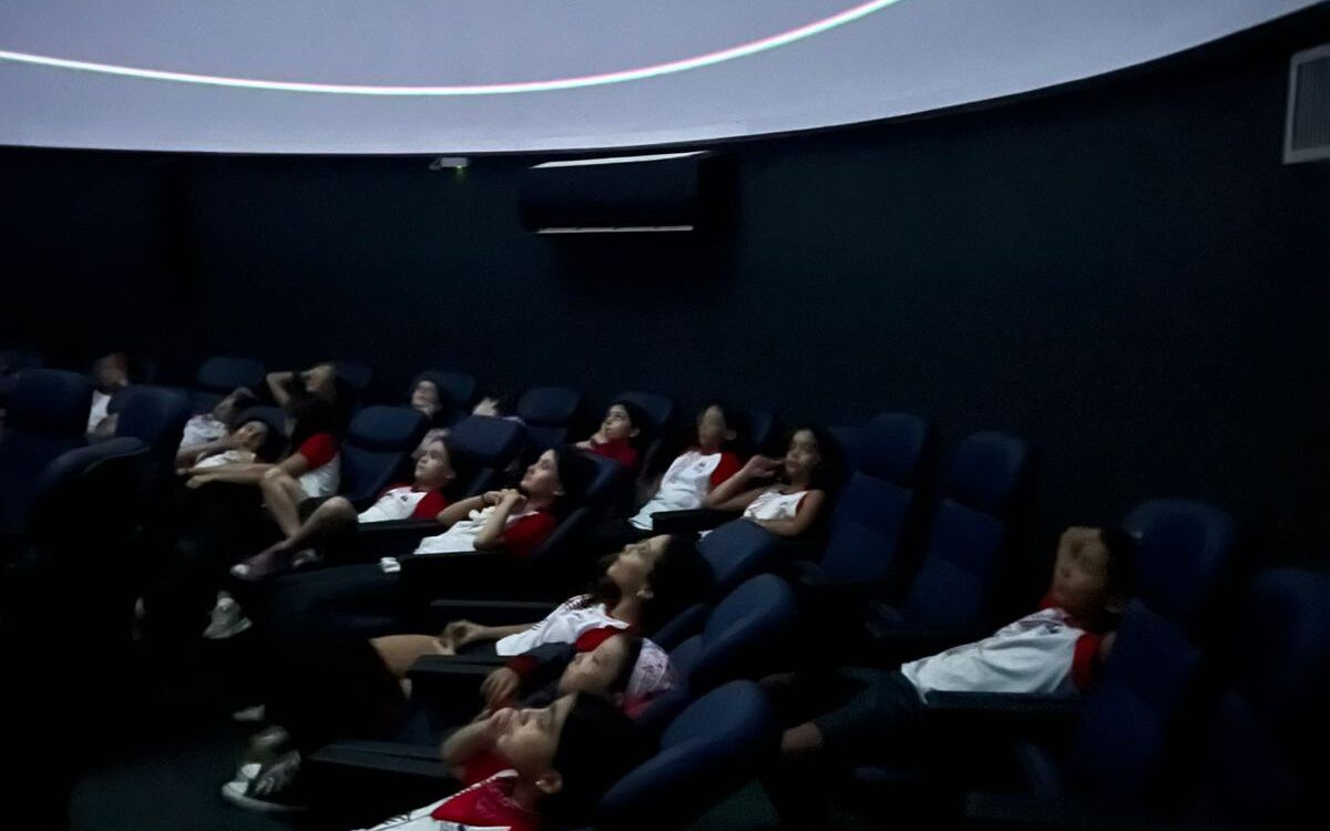 Alunos do 5º ano assistem a uma projeção no Planetário PUC Minas