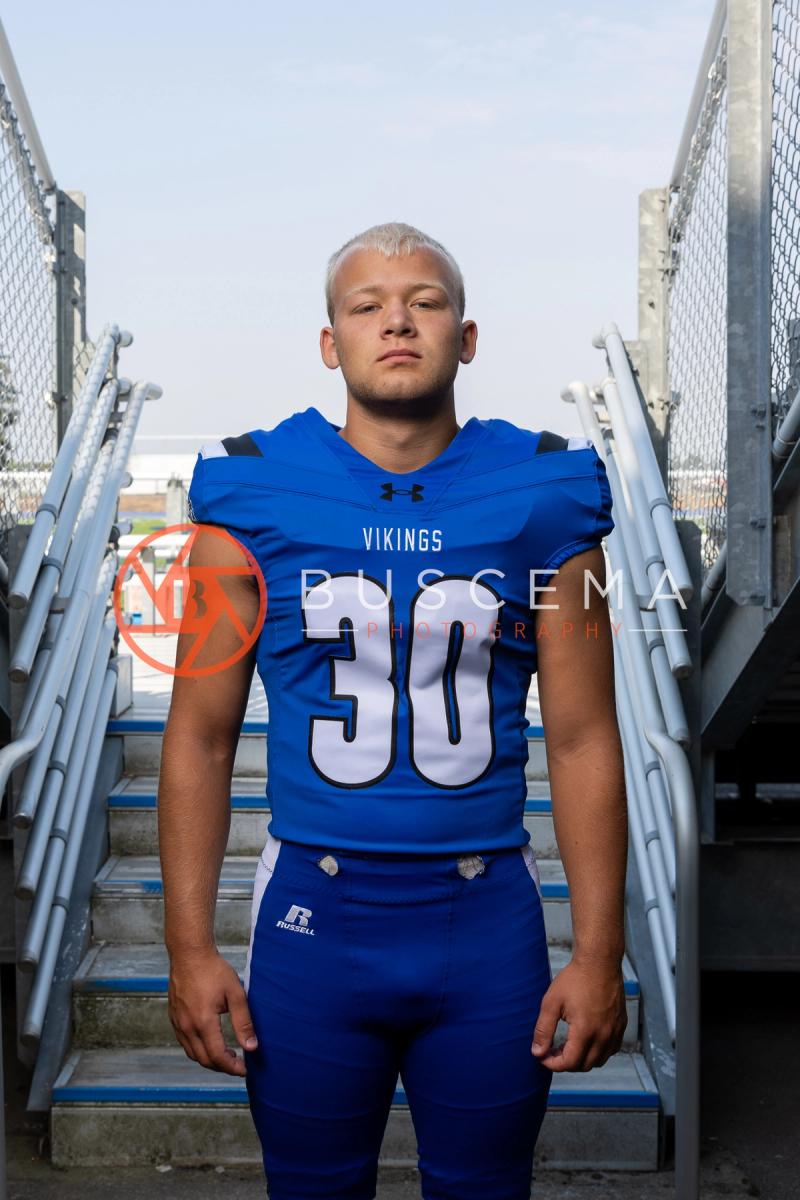 Coeur d'Alene High School Vikings football player in a number 30 jersey on the stadium bleacher steps