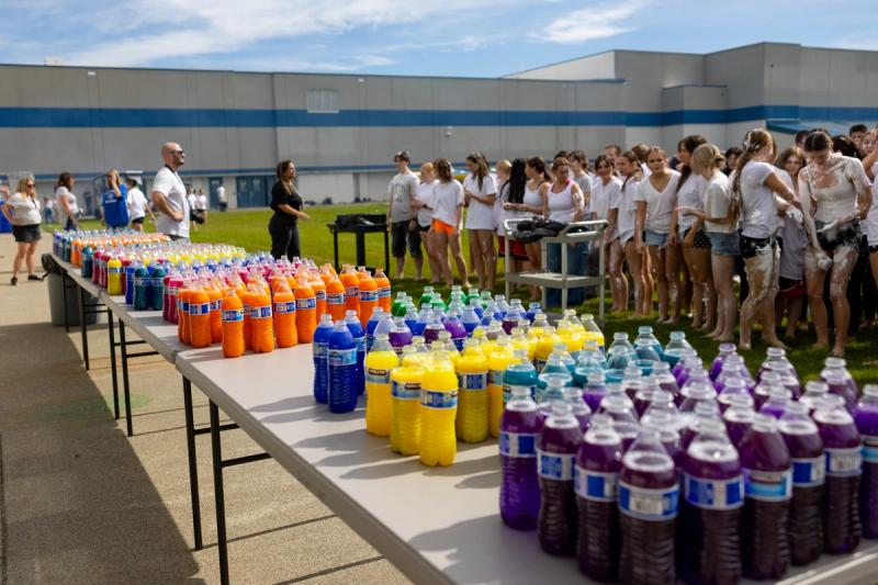 Bottles of colored powder lined up on tables before the color throw