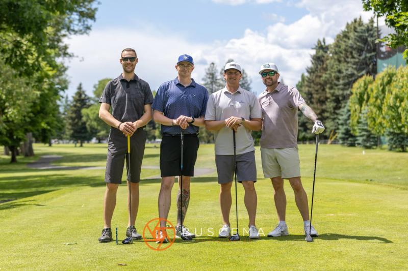 A foursome lined up with their clubs on the tee