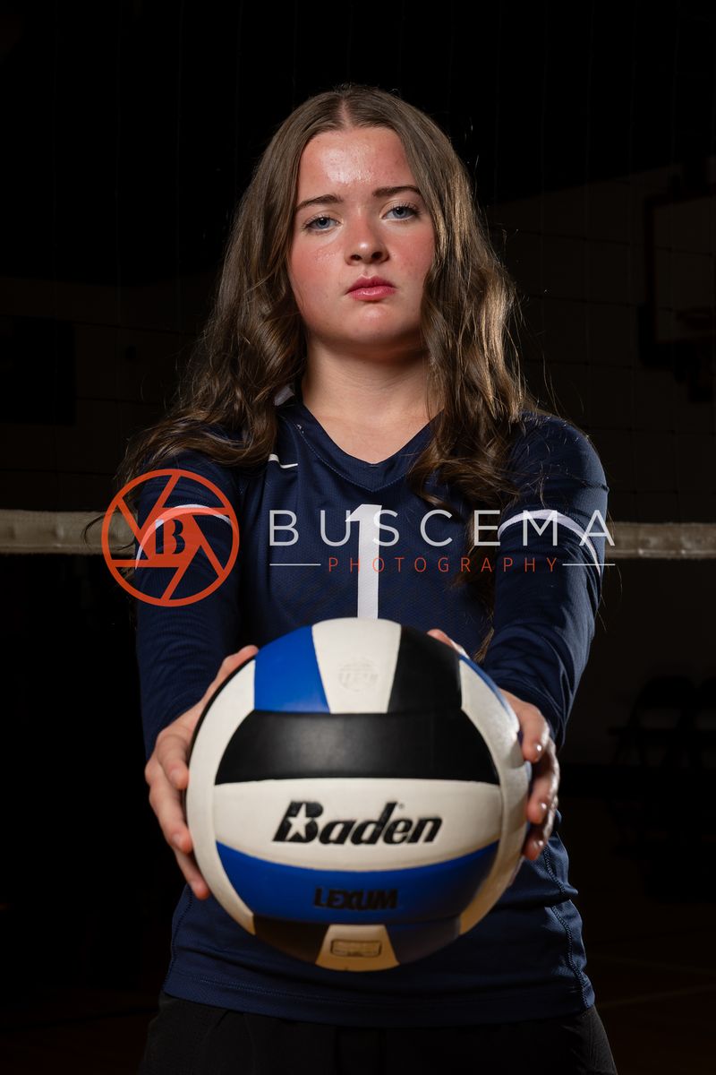 Coeur du Christ Academy volleyball player holding a volleyball at the net