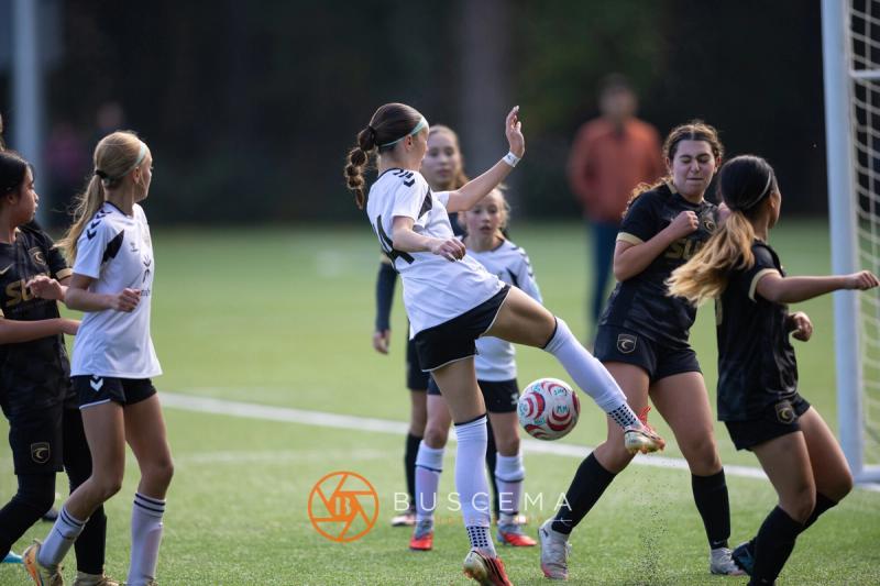 Sting 13G Academy player kicking through a crowd of Western WA Surf players