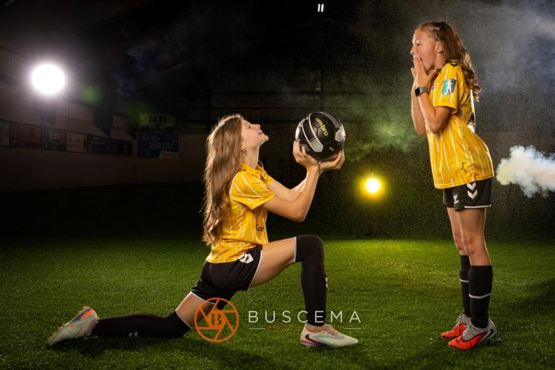 Two Sting 13G Academy players playing catch with a ball under the lights