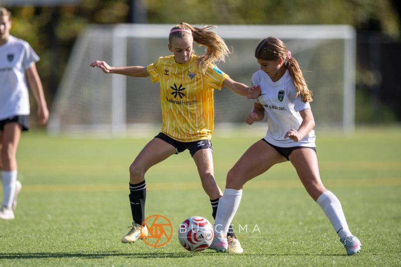 Sting 13G Academy player shielding the ball from a Harbor Premier player