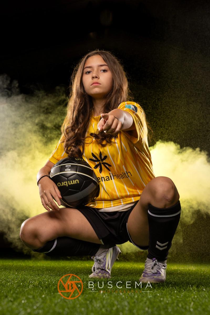 Sting 13G Academy player crouched with a ball, pointing at the camera