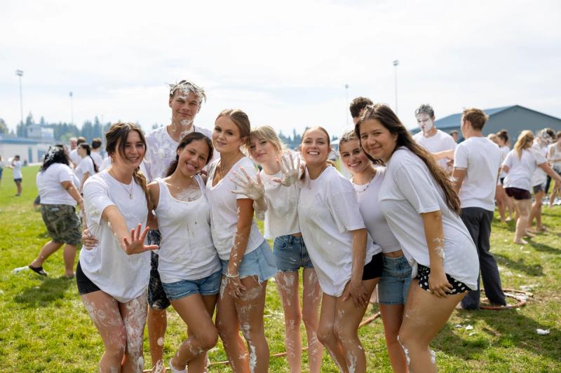 Coeur d'Alene seniors in white shirts posed together during the shaving cream fight