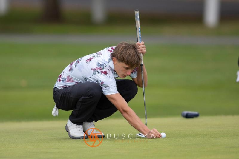 Boys golfer setting his ball down on the green at the 6A state golf championships at Avondale Golf Club