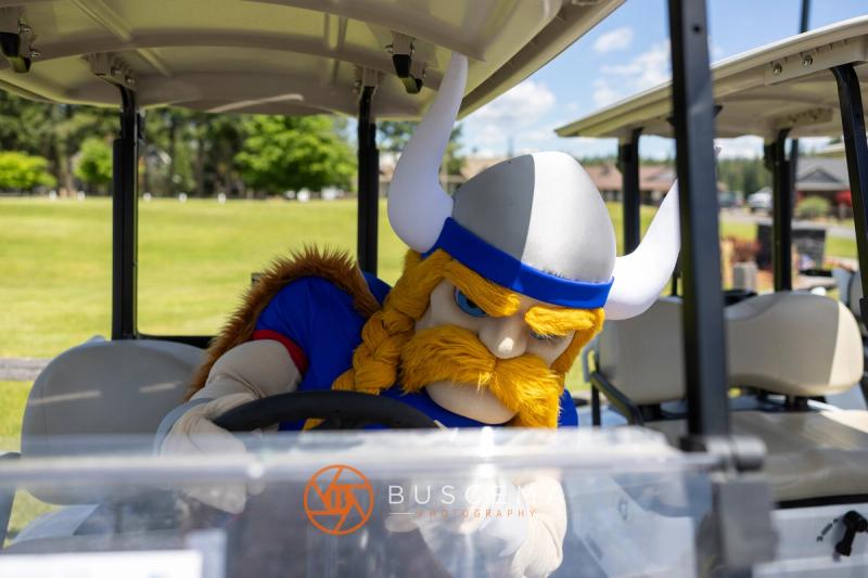 The Viking mascot behind the wheel of a golf cart