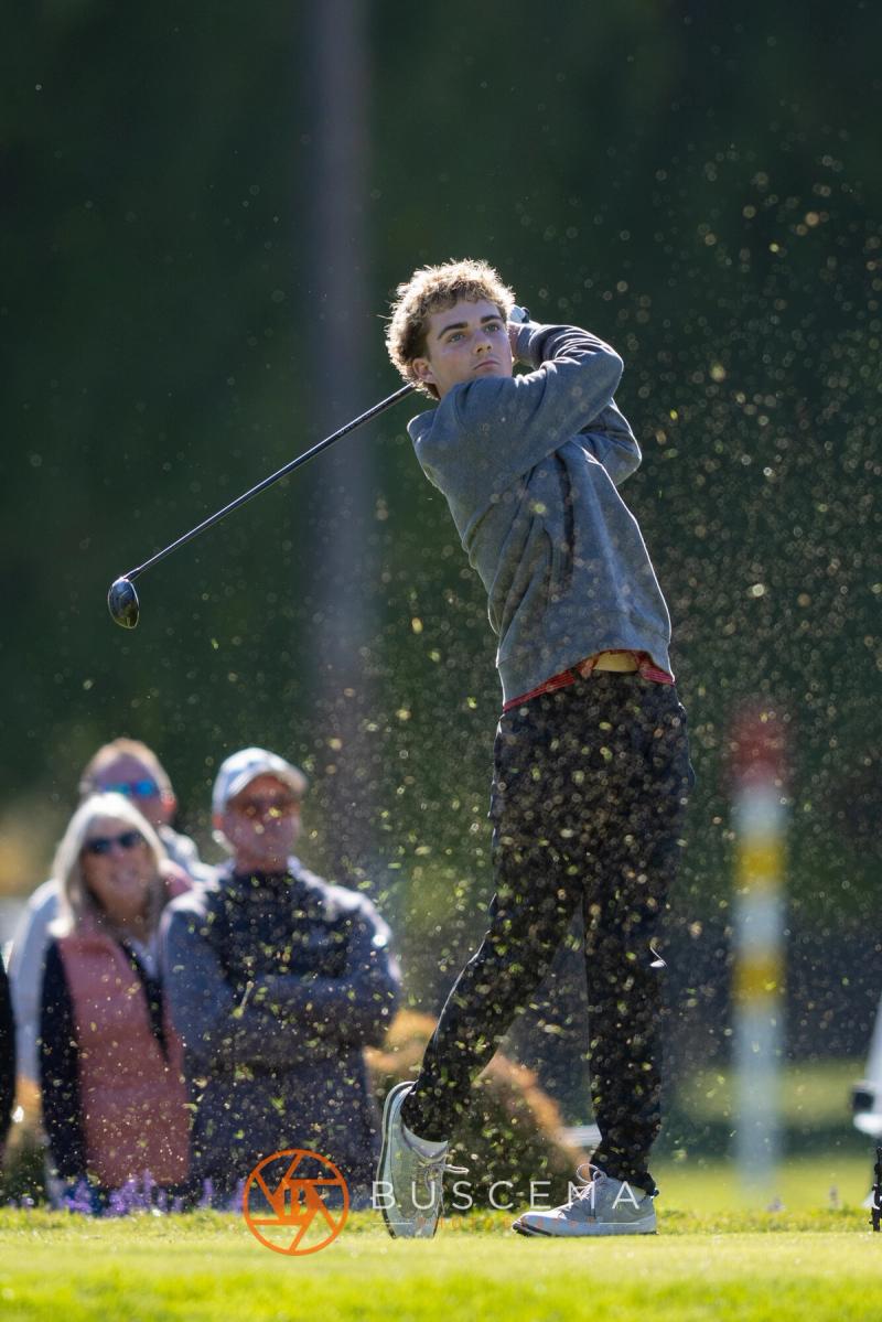 Boys golfer finishing his drive as the gallery watches at the 6A state golf championships at Avondale Golf Club