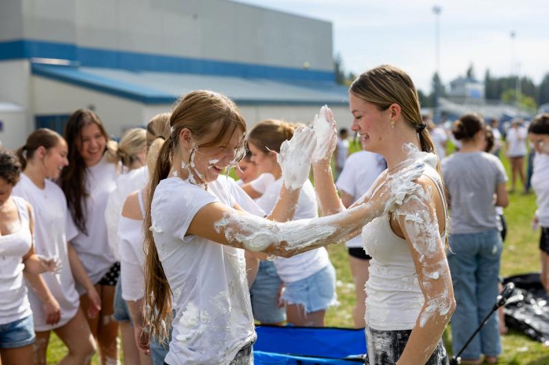 Two Coeur d'Alene seniors covered in shaving cream facing each other