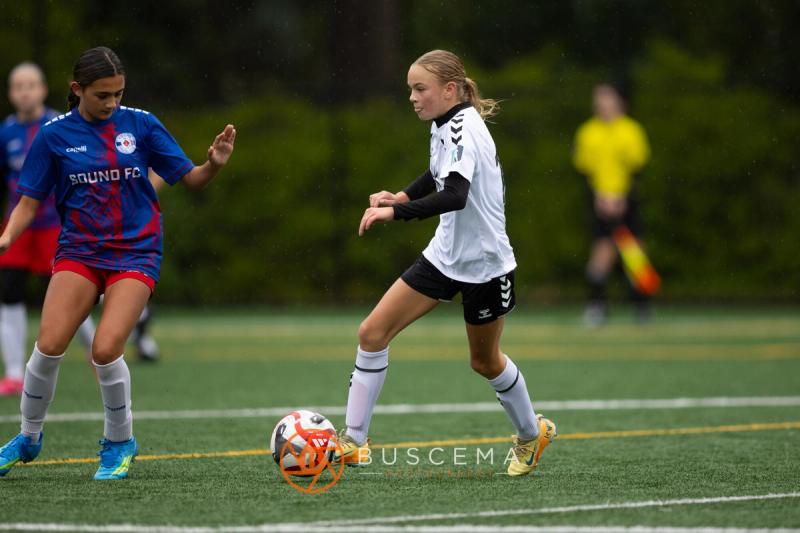 Sting 13-14G Academy player on the ball with a Sound FC defender closing