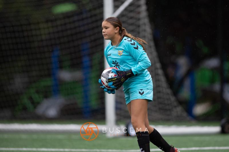 Sting 13-14G Academy goalkeeper holding the ball in her goal against Sound FC