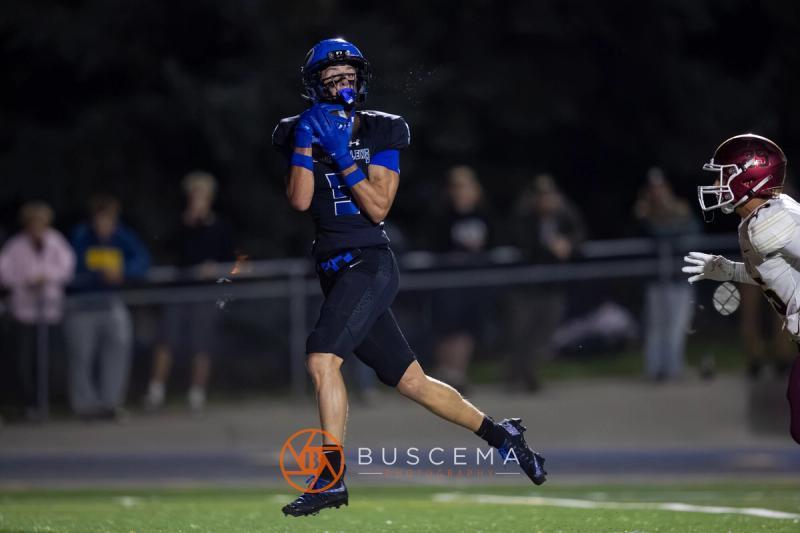 A Coeur d'Alene player carries the ball upfield with Rigby in pursuit