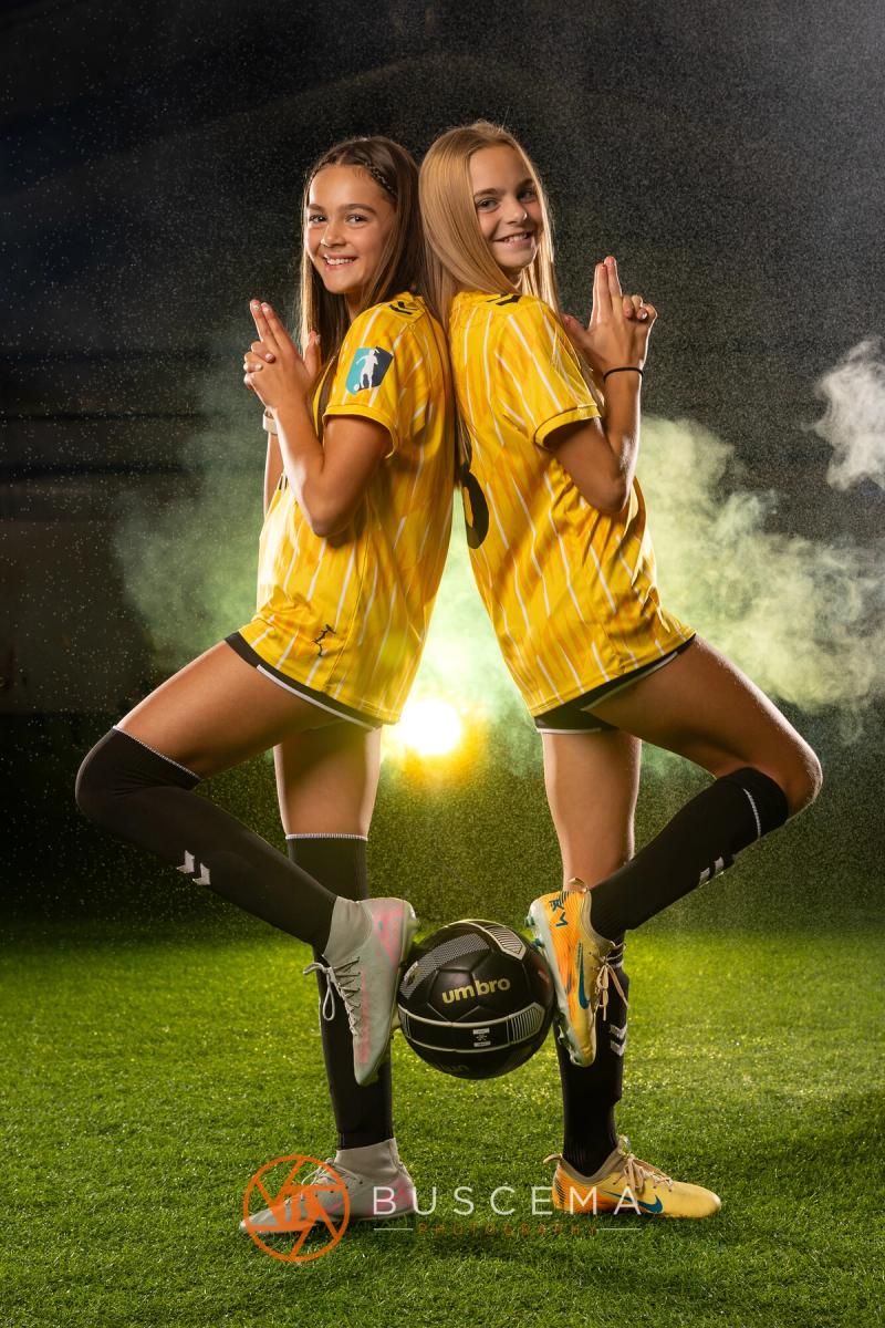 Two Sting 13G Academy players back to back with a ball between them