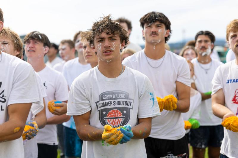 Coeur d'Alene seniors in gloves holding colored powder before the throw