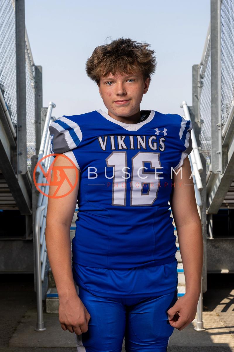 Coeur d'Alene Vikings football player in a number 16 jersey on the bleacher steps