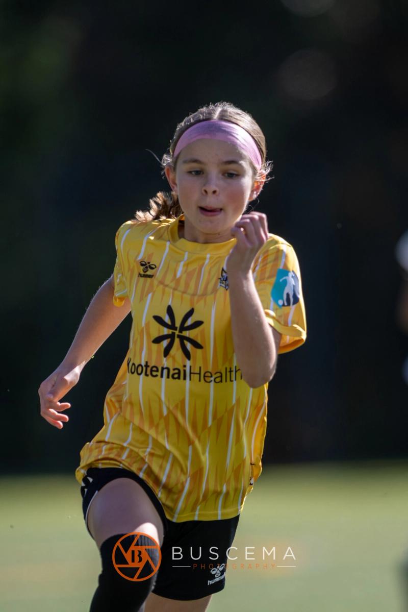 Smiling Sting 13G Academy player jogging back up the field