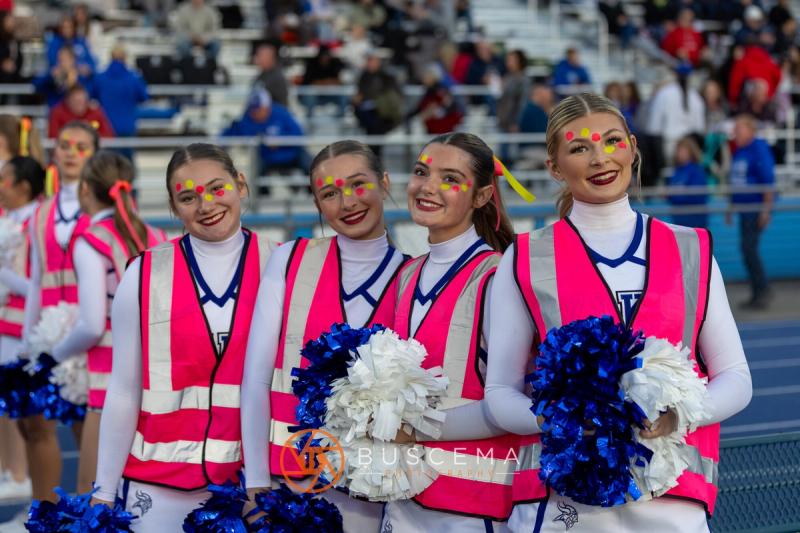 Four Coeur d'Alene cheerleaders in pink posed together with pompoms