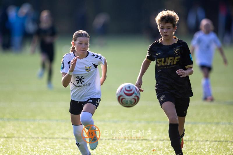 Sting 13G Academy player dribbling with a Western WA Surf player chasing
