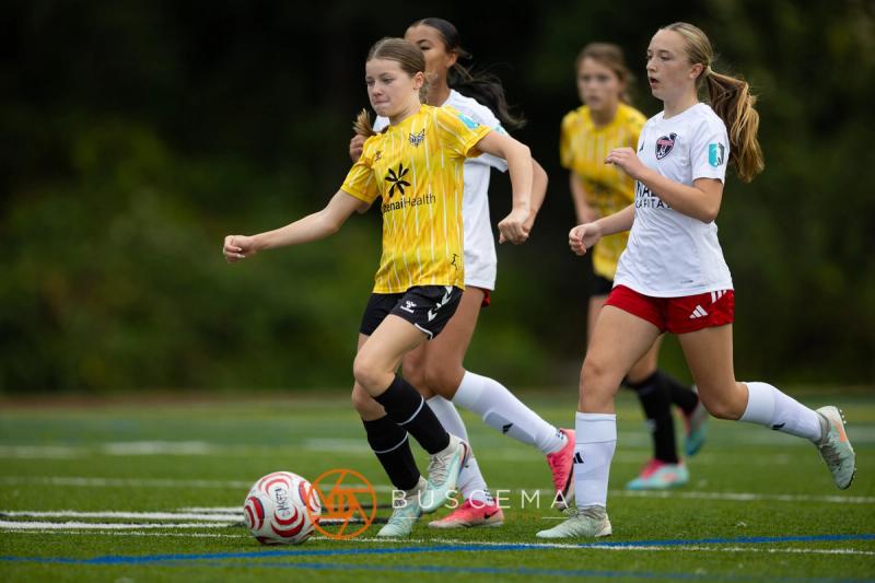 Sting 13-14G Academy player on the ball with a Mt. Rainier defender alongside