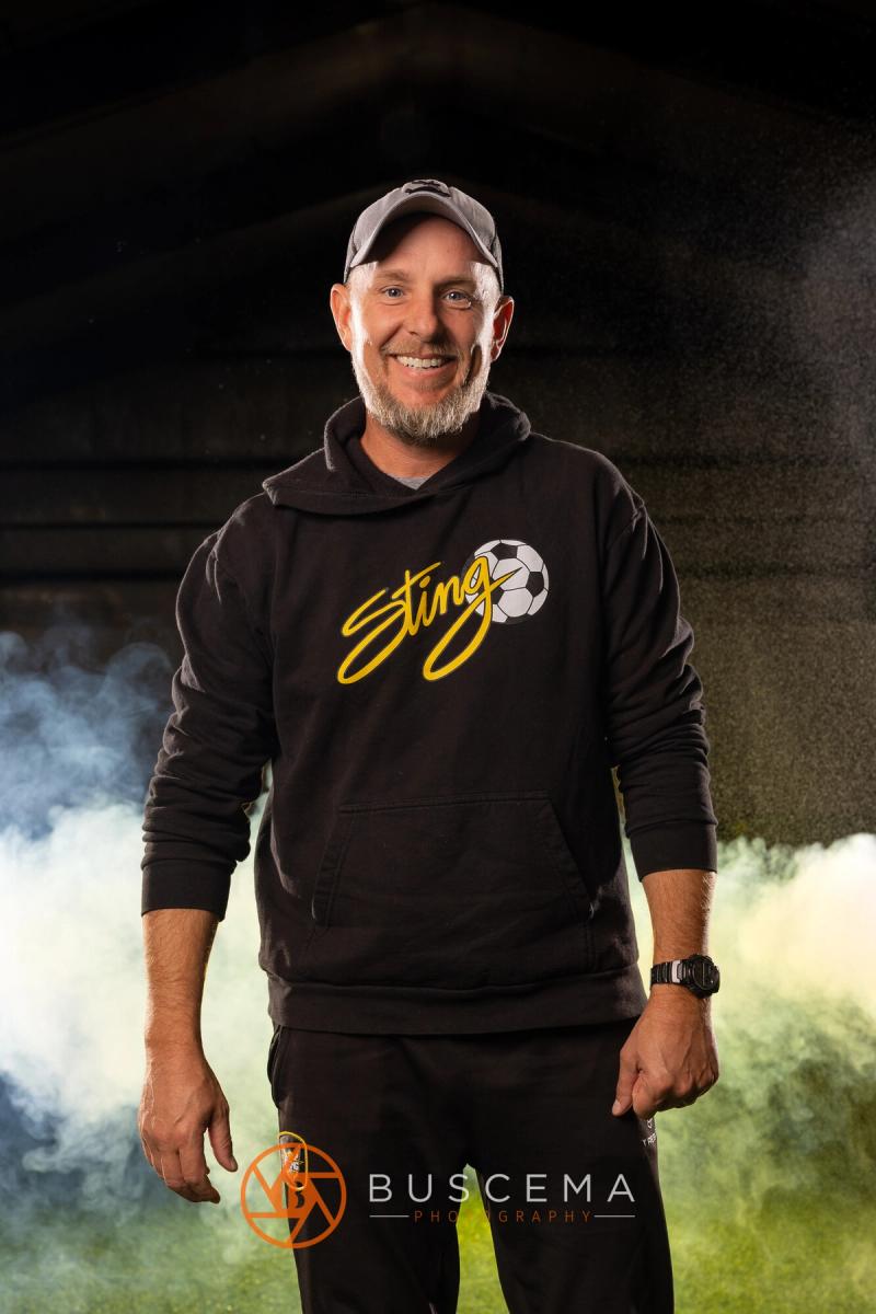 Sting 13G Academy coach smiling in his Sting hoodie