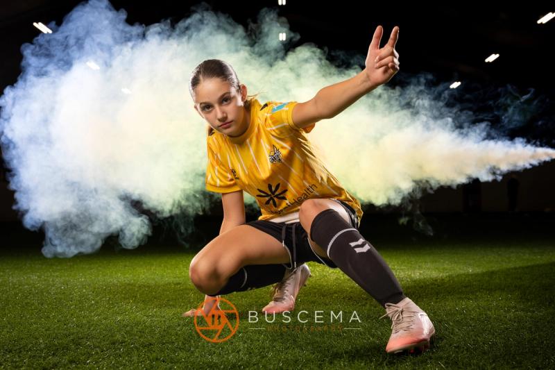 Sting 13G Academy player striking a pose with smoke blowing behind her