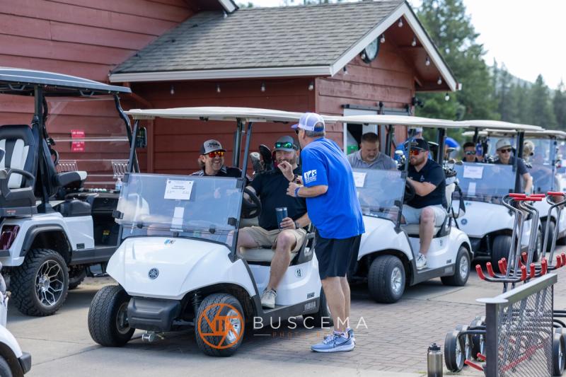 Golfers in carts lined up outside the clubhouse before the shotgun start