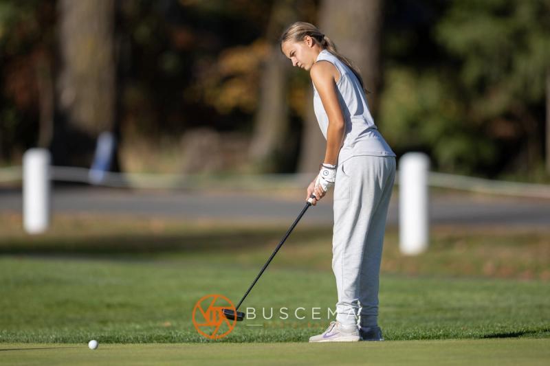 Girls golfer putting on a sunny green at the 6A state golf championships at Avondale Golf Club