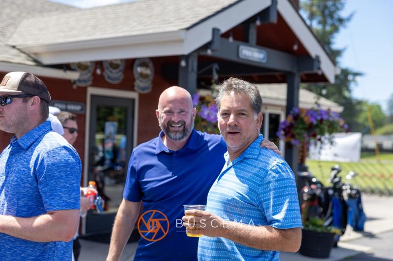 Two golfers smiling arm in arm outside the Avondale pro shop