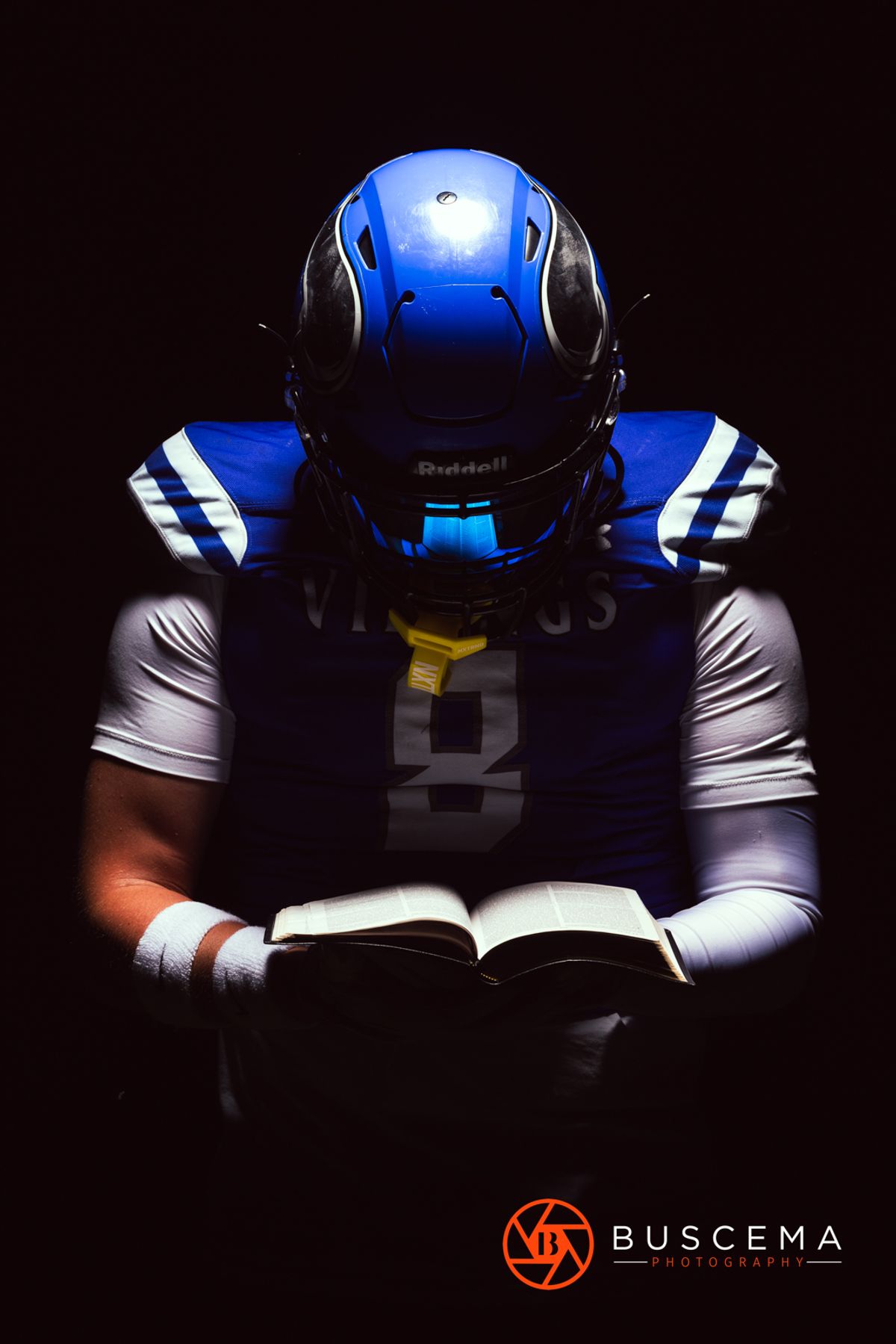 Football player holding the Bible - Coeur d'Alene Senior Portraits. By Jason Buscema, Coeur d'Alene, Idaho Senior Photographer.