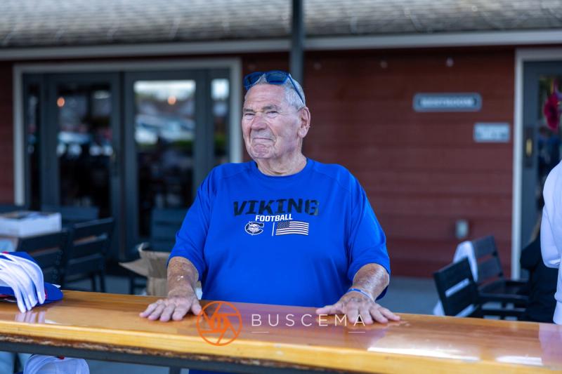 A longtime Viking supporter in a Viking Football shirt smiling at the clubhouse bar