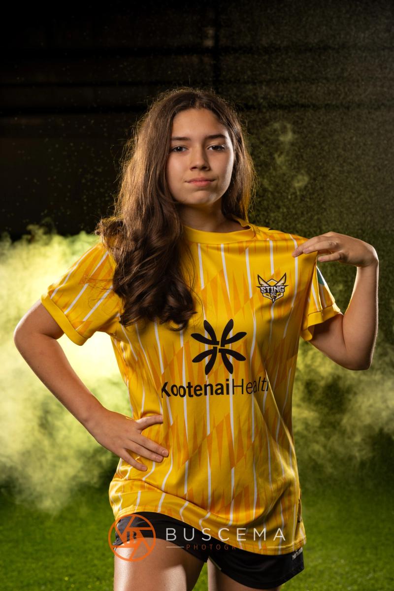Sting 13G Academy player tugging her jersey in front of the smoke