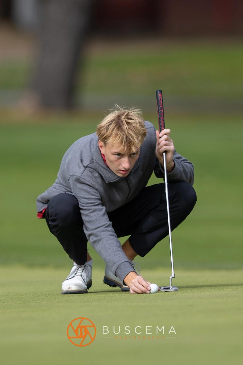 Boys golfer marking his ball on the green at the 6A state golf championships at Avondale Golf Club