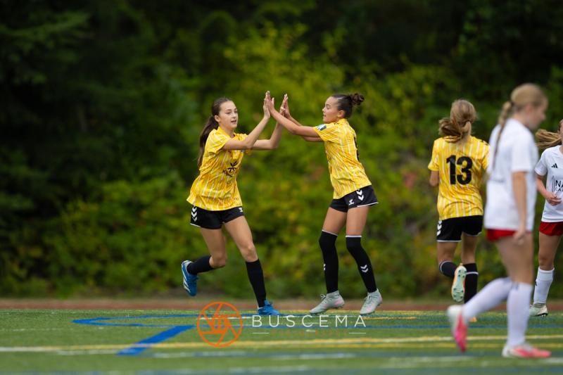Two Sting 13-14G Academy players high-fiving during the Mt. Rainier game