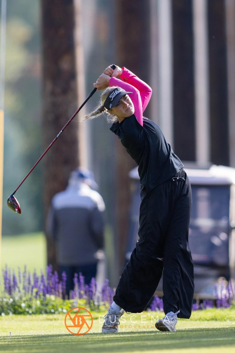 Girls golfer in pink sleeves following through on her drive at the 6A state golf championships at Avondale Golf Club