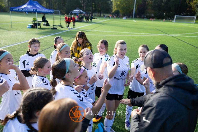 Sting 13G Academy players gathered around their coach on the sideline