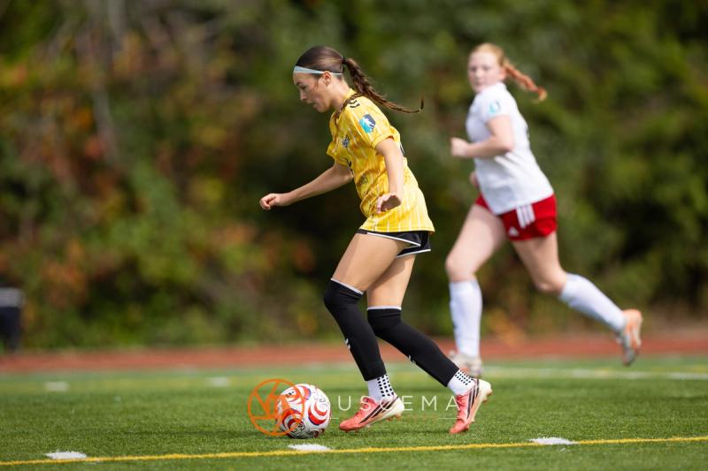 Sting 13-14G Academy player driving the ball past a Mt. Rainier defender