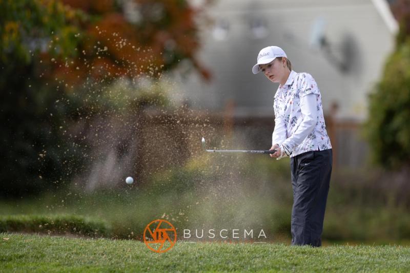 Golfer blasting out of a bunker with sand flying at the 6A state golf championships at Avondale Golf Club