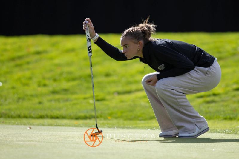 Girls golfer crouched low reading her putt at the 6A state golf championships at Avondale Golf Club