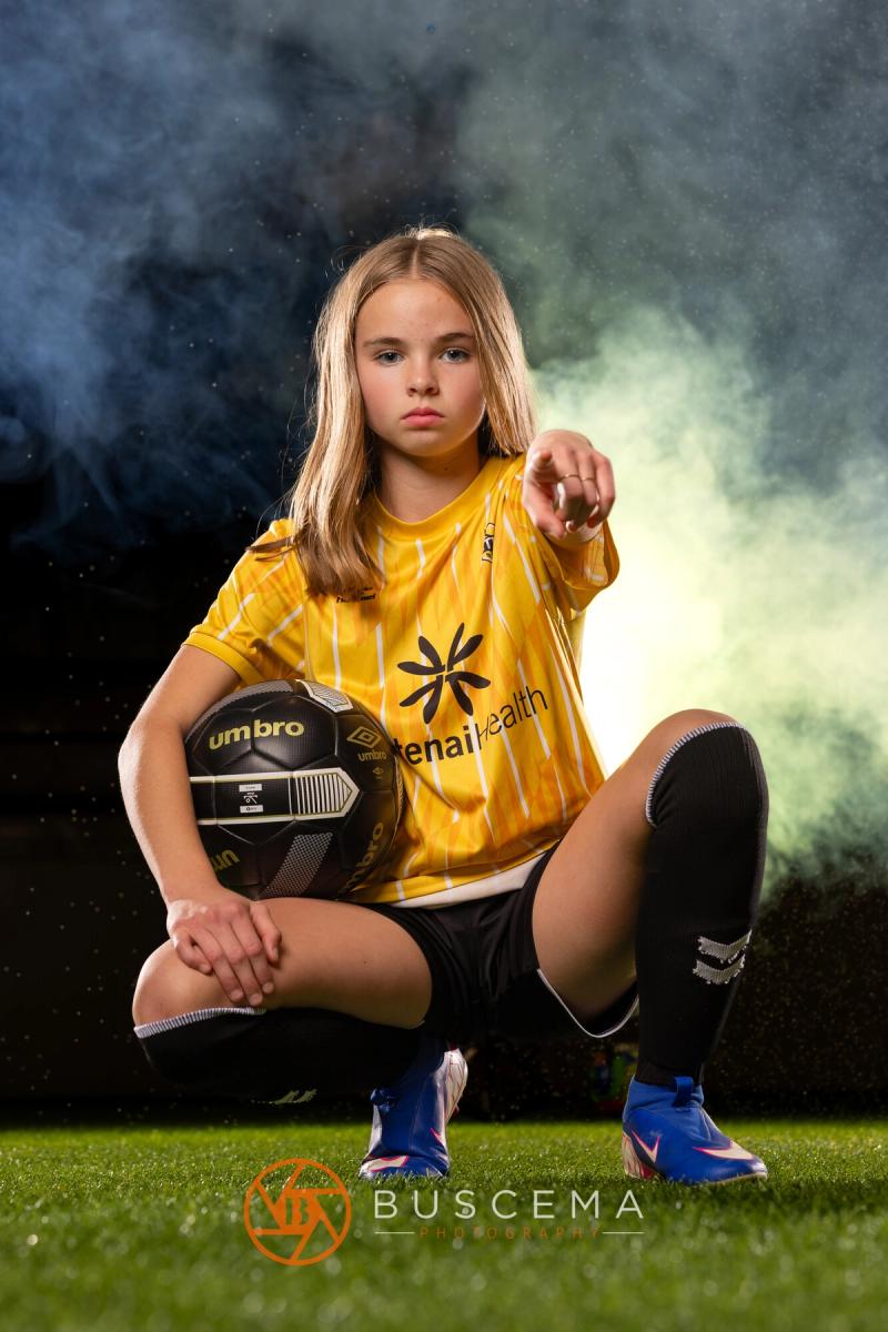 Sting 13G Academy player kneeling with a ball and pointing