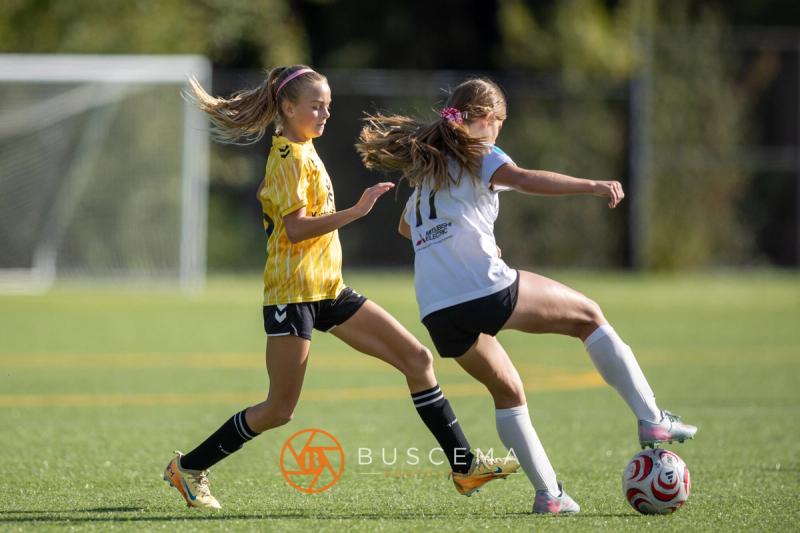 Sting 13G Academy player fighting for the ball with a Harbor Premier player