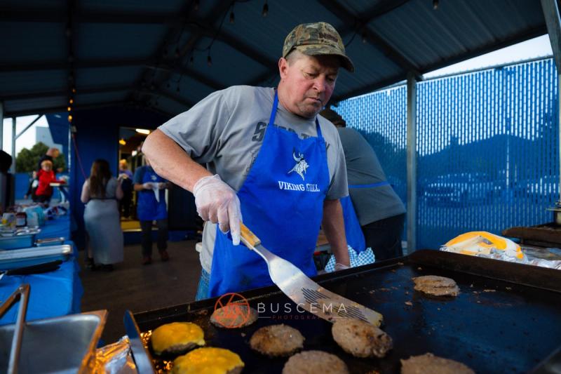 A volunteer grilling burgers in a Viking Grill apron at the Coeur d'Alene concession stand